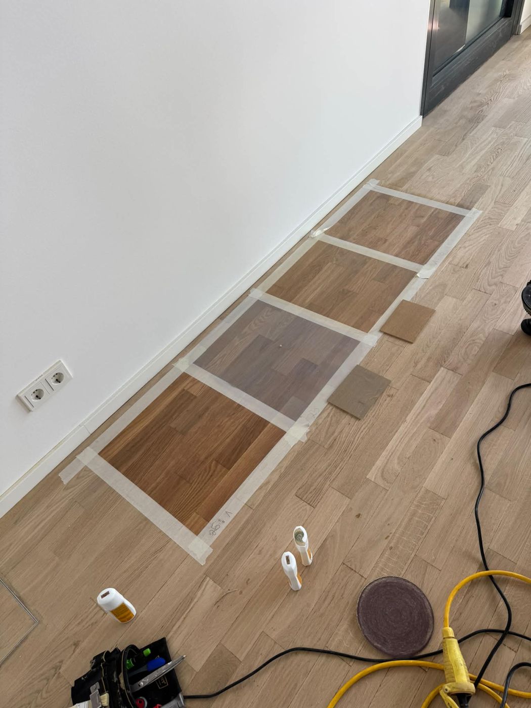 Four colour samples laid out directly on the client's floor