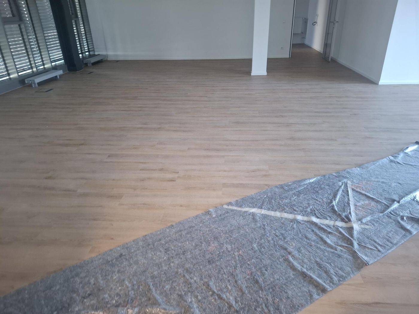 Light self-adhesive design flooring on polyurethane underlay in an office
