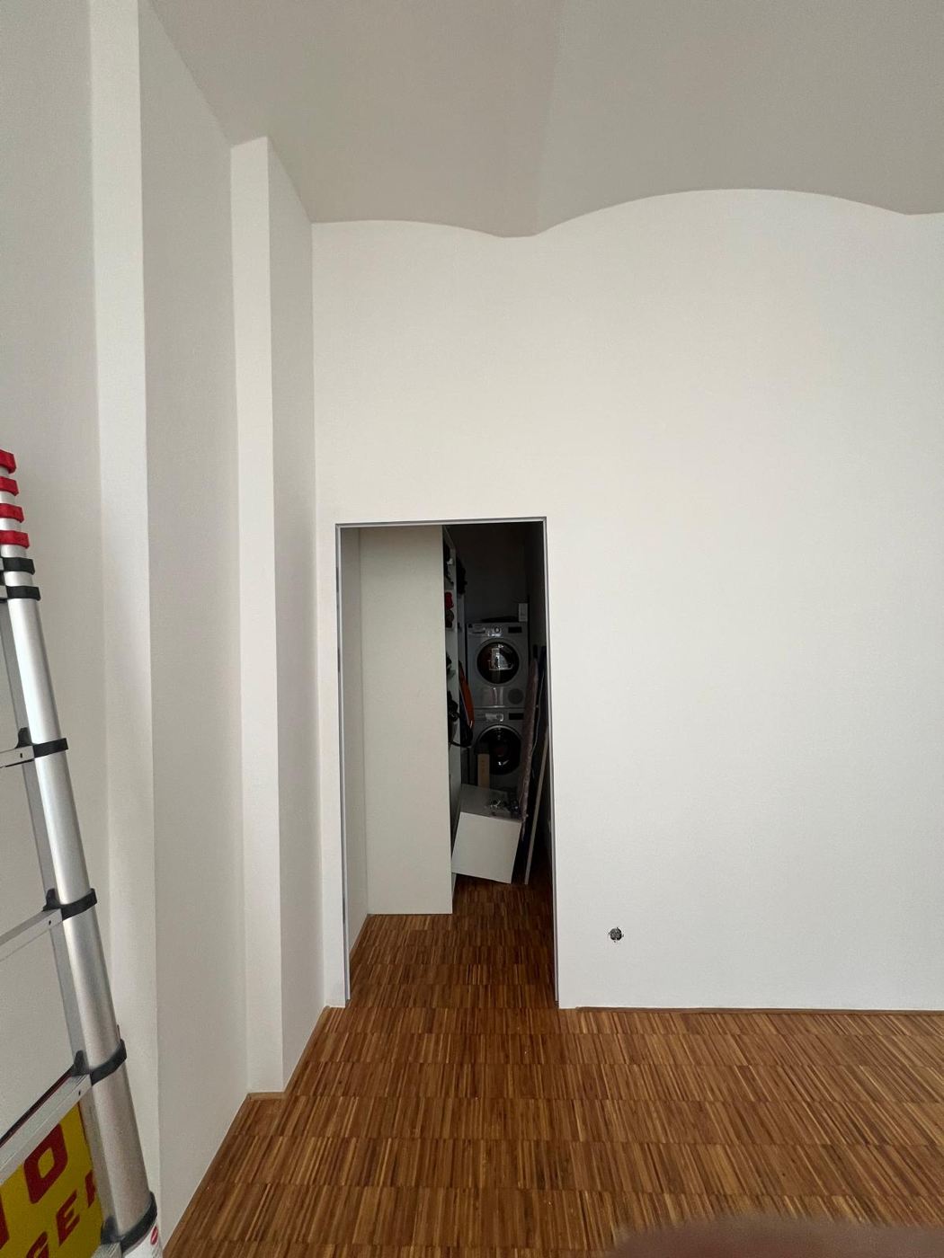 Apartment with vaulted ceiling, simple painting work and restored industrial parquet