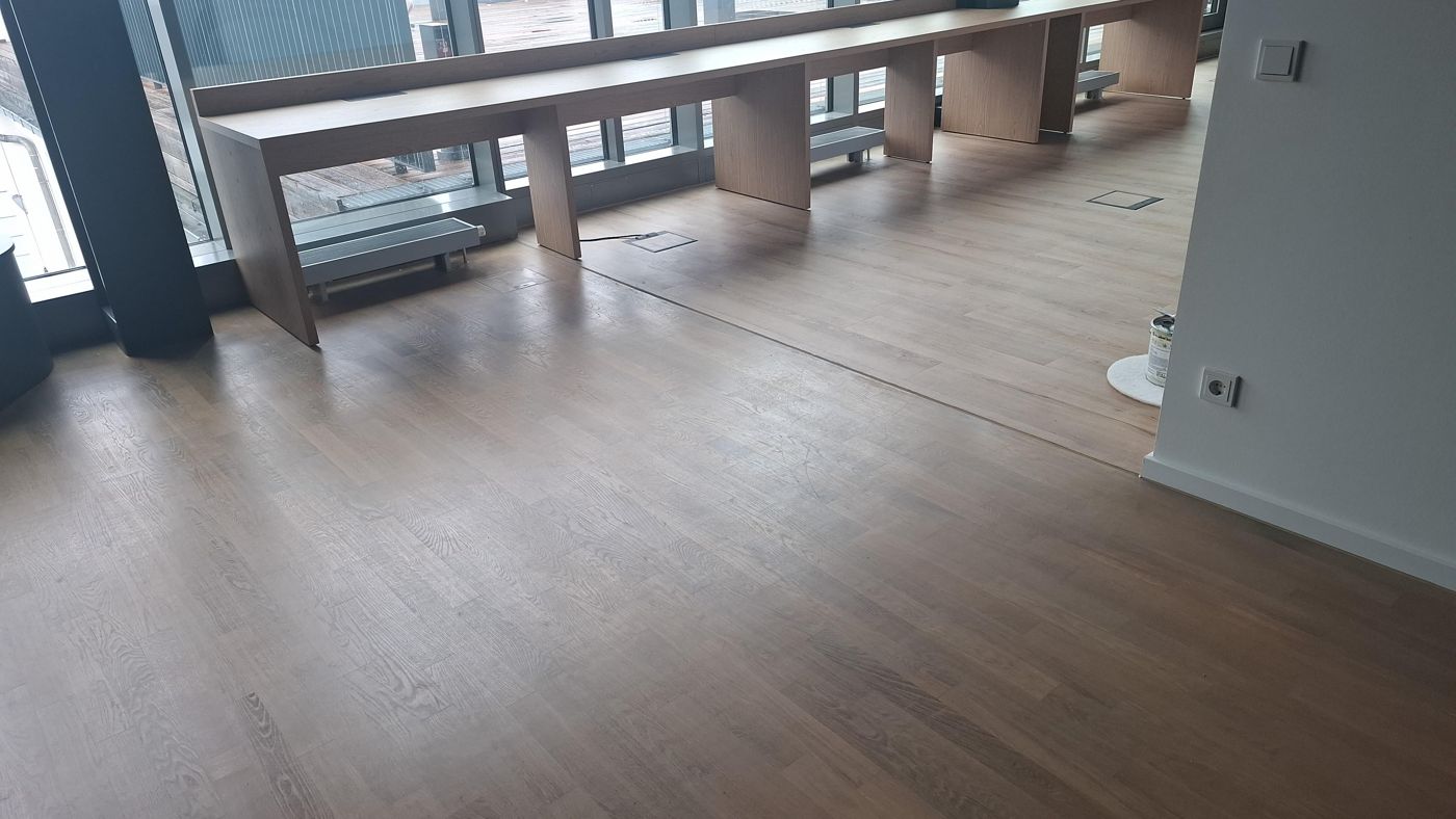 Transition from pigmented oiled parquet to design flooring in an office
