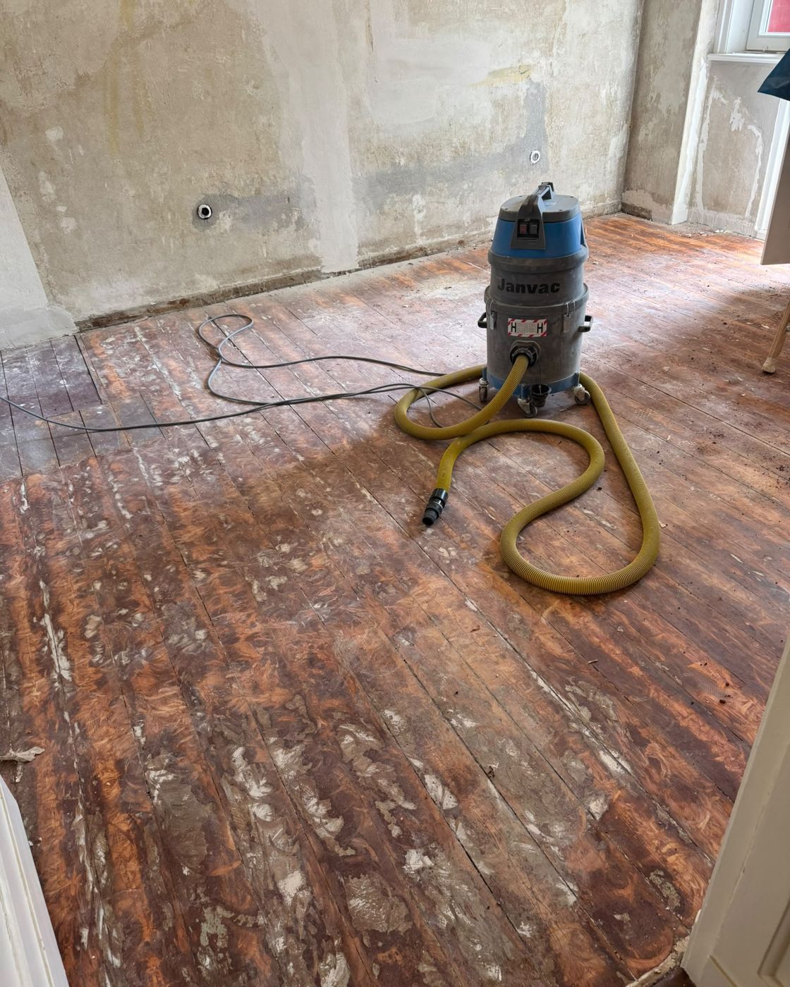 Old pine floorboards with paint and filler residues before sanding