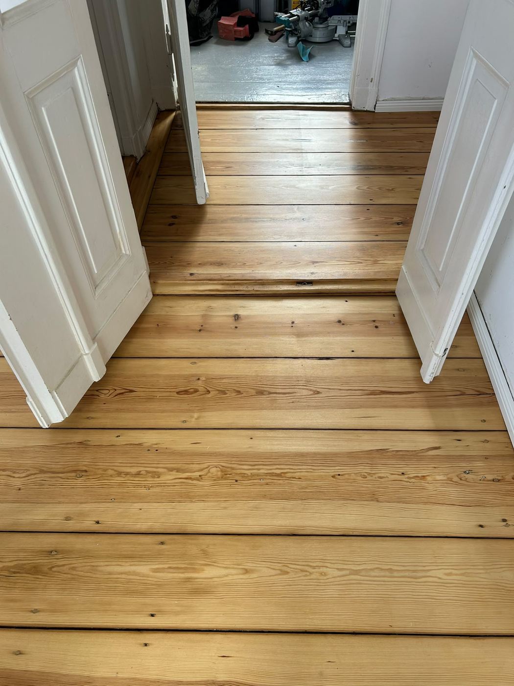 Hallway with uncovered, sealed pine floorboards