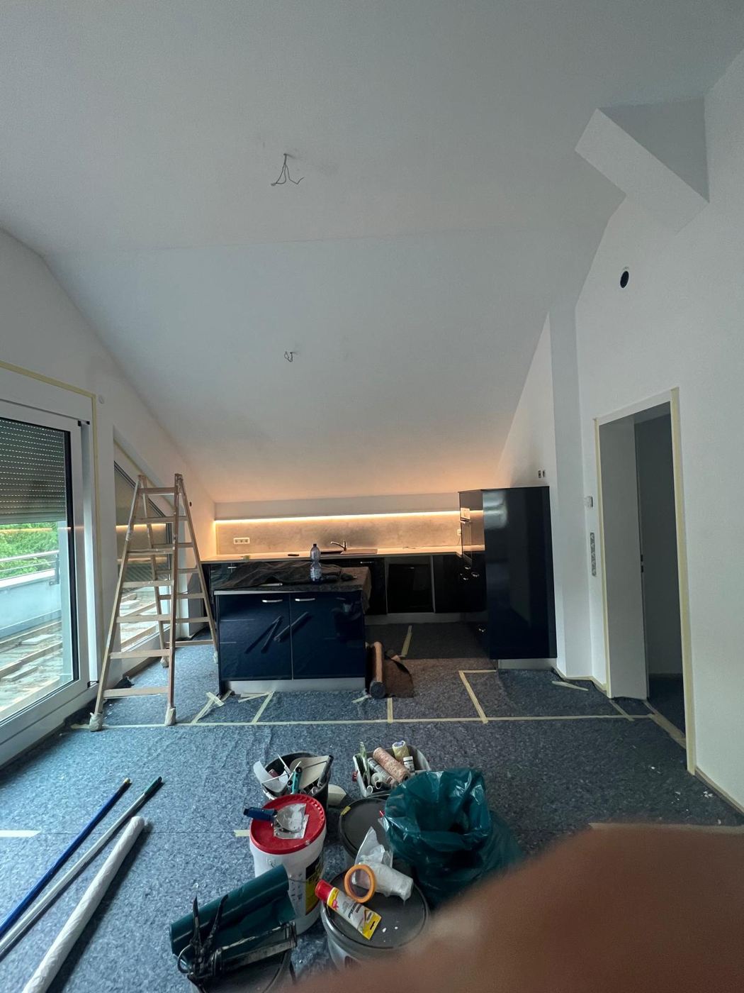 Painting work in an open kitchen with covered fitted kitchen