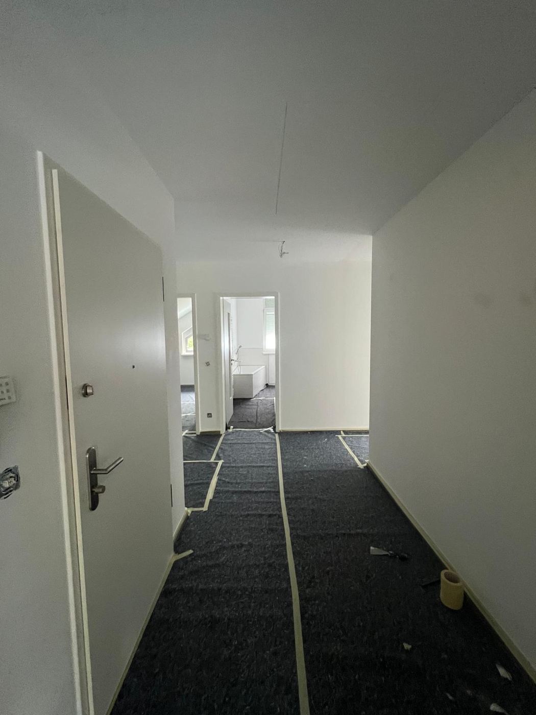 Apartment hallway with white ceiling and light walls after painting